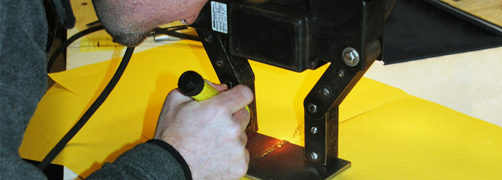 Inspector Using the Magnetic Particle Method to Assess Weld Submitted for Qualification Testing